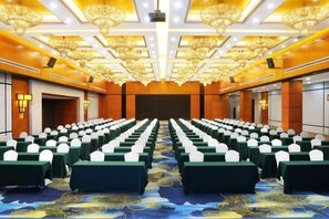 A conference room with rows of tables and chairs, a patterned carpet, and a large screen at the front. - Holiday Villas Airport (Guangzhou Baiyun International Airport) (Guangzhou)