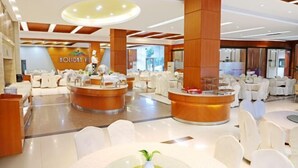 A modern hotel lobby with multiple reception desks, white chairs, and a central dining area with round tables. - Holiday Villas Airport (Guangzhou Baiyun International Airport) (Guangzhou)
