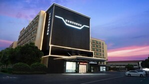 A modern hotel building with a prominent digital display on the facade. - Holiday Villas Airport (Guangzhou Baiyun International Airport) (Guangzhou)