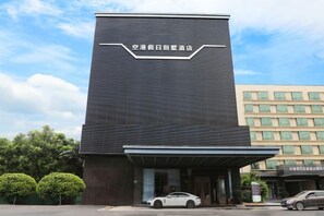 A modern building with a prominent entrance and a sign above it. - Holiday Villas Airport (Guangzhou Baiyun International Airport) (Guangzhou)