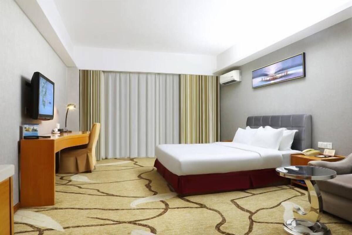 Une chambre d’hôtel équipée d’un lit, d’un bureau, d’une chaise et d’un téléviseur.