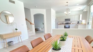 Un comedor con una mesa de madera, sillas y plantas en macetas.