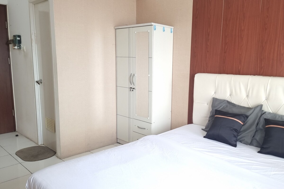Une chambre à coucher avec un lit, une armoire et une porte.