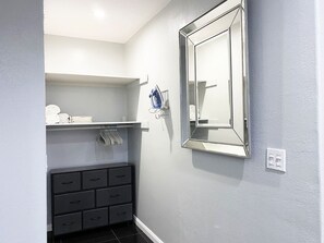 Une salle de bain avec un miroir, un porte-serviettes et un meuble noir.