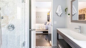 Ein modernes Badezimmer mit Dusche, Waschbecken und Spiegel.