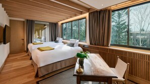 A hotel room with two beds, a wooden ceiling, large windows, a dining table, and a chair. - GLAMDAY STYLE HOTEL SUITE YAMANOFUMOTO (Karuizawa)