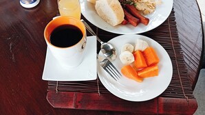 Un repas composé de riz, de pain et de légumes, servi sur une table en bois.