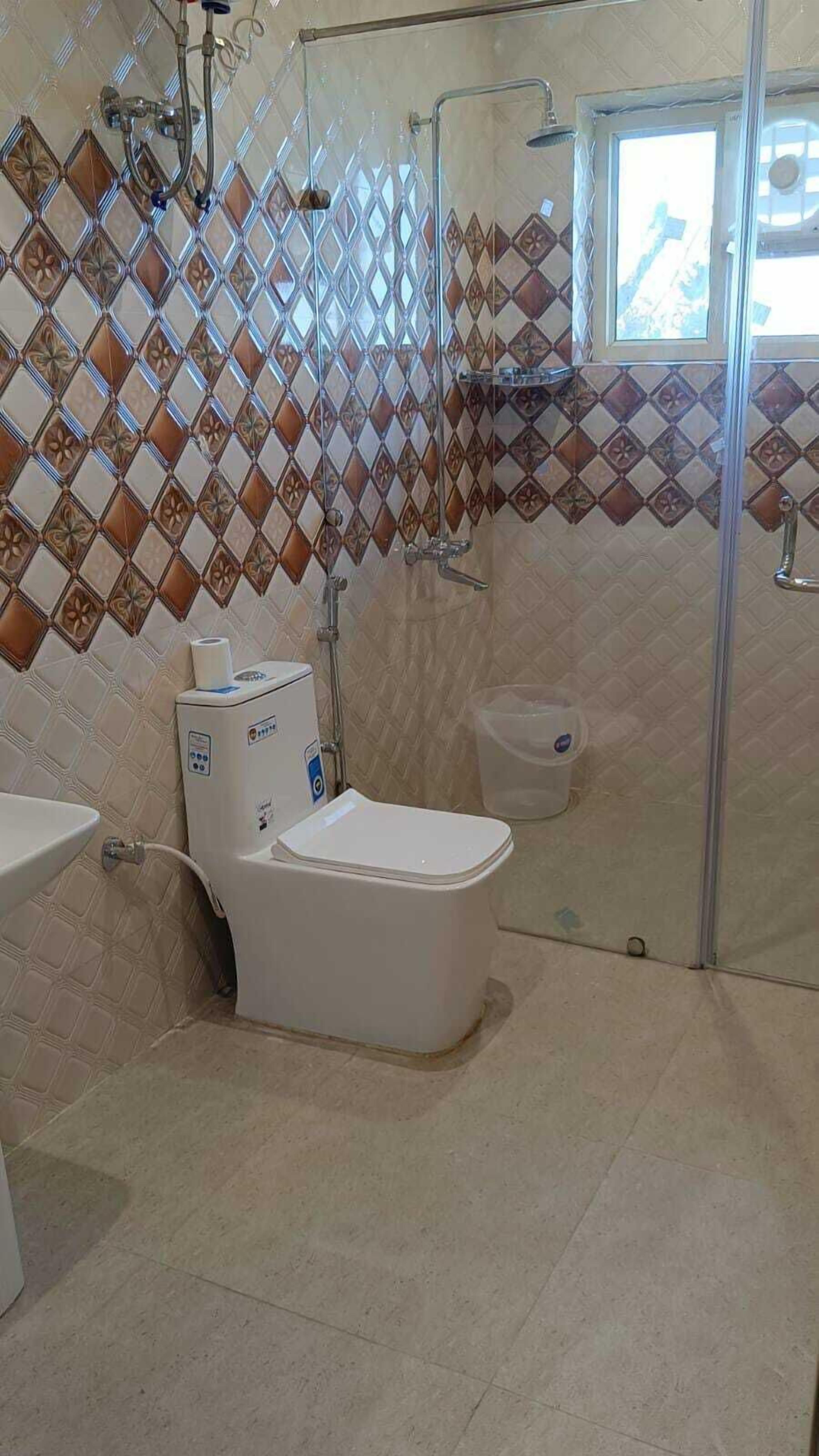 A bathroom with a toilet, a shower, and a sink.