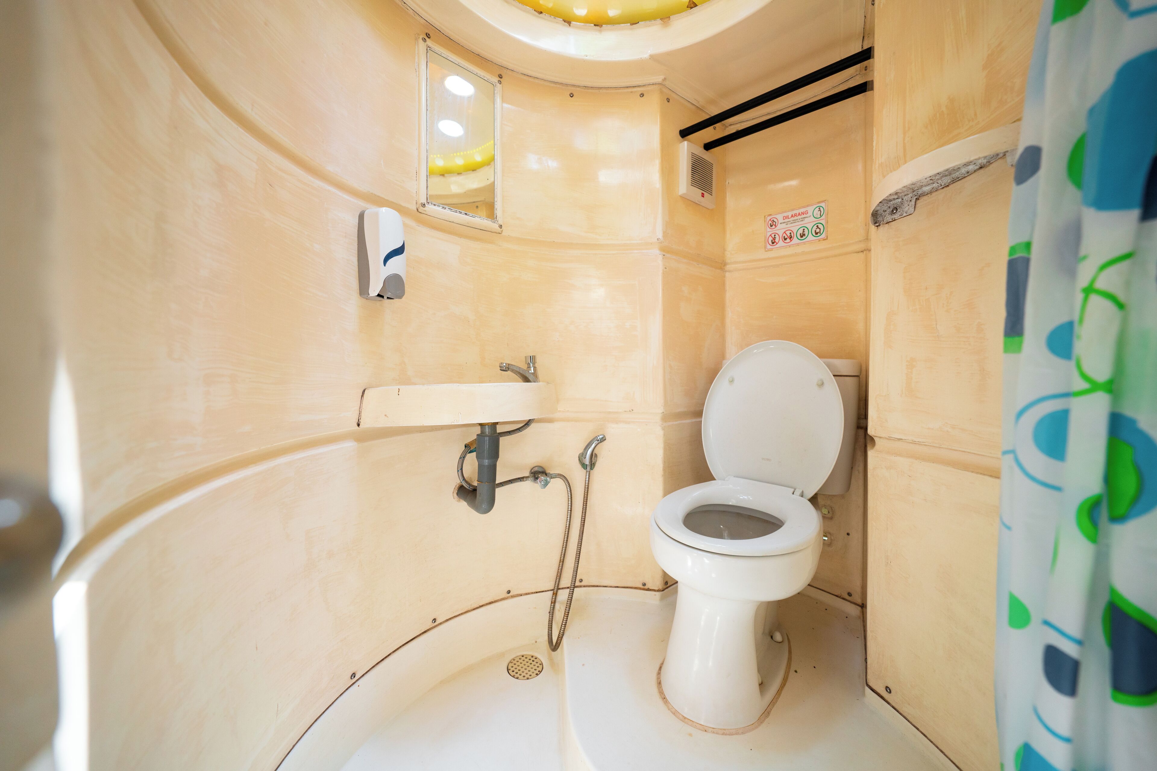Un baño pequeño y funcional, con inodoro blanco, lavamanos y ducha.