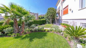 Un jardin bien entretenu, agrémenté de palmiers, d’une pelouse et de divers arbustes.
