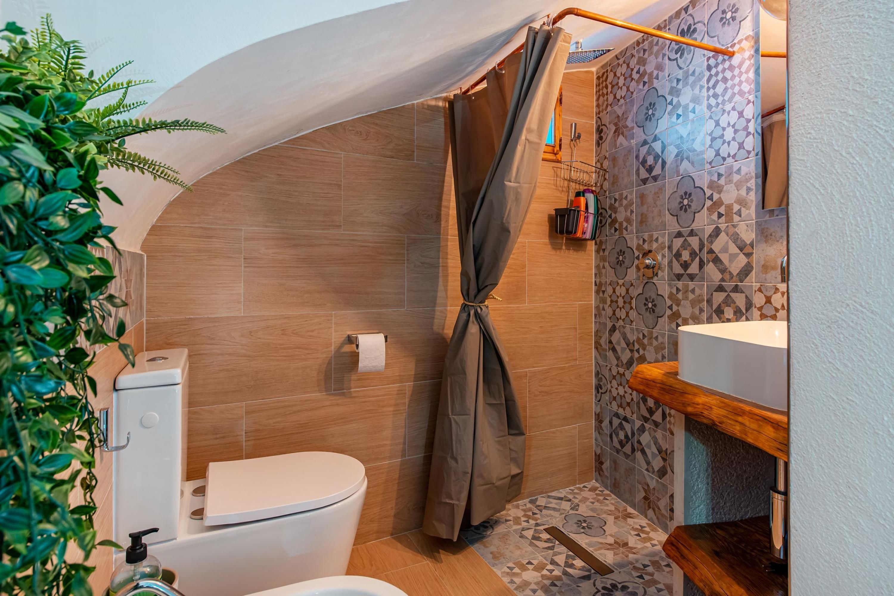 A compact bathroom with a shower, toilet, and sink.