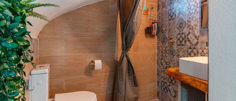 A compact bathroom with a shower, toilet, and sink.