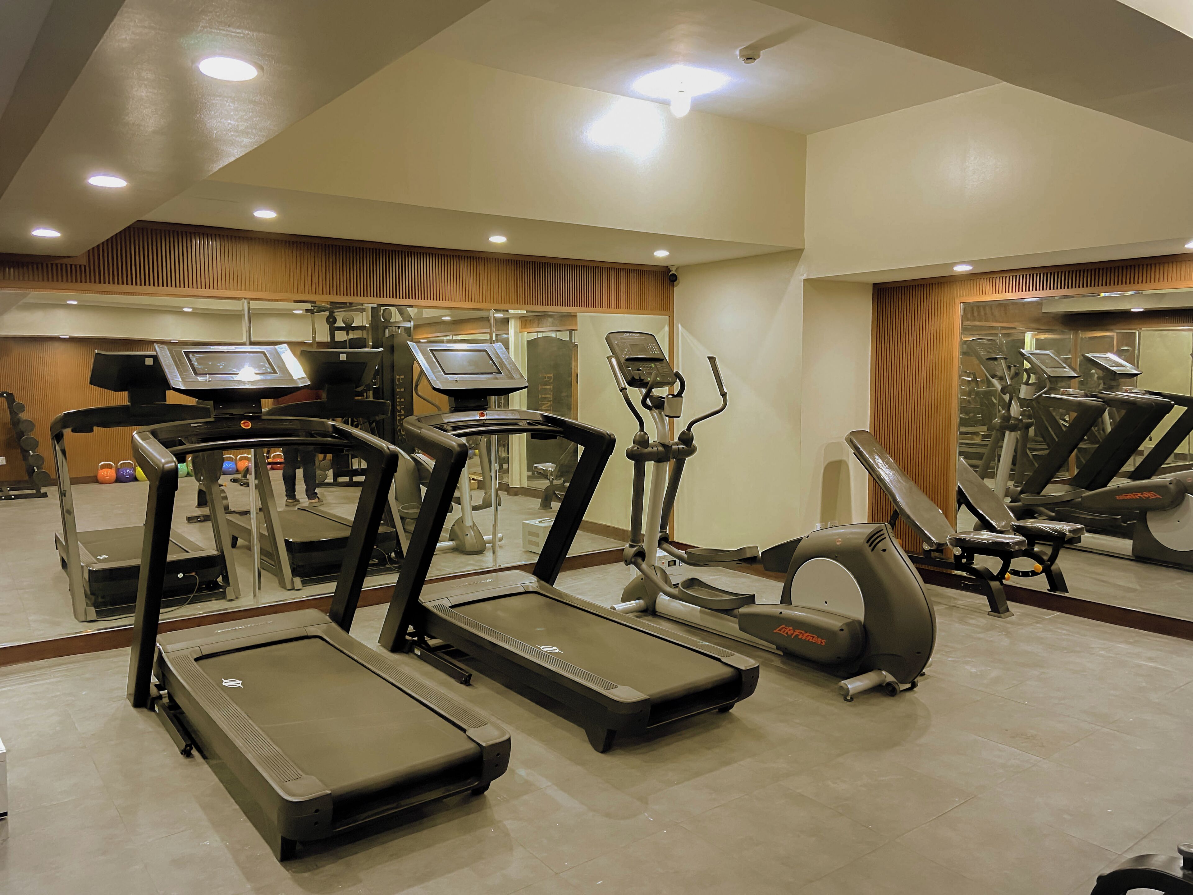 A gym with treadmills, elliptical machines, and weight equipment.
