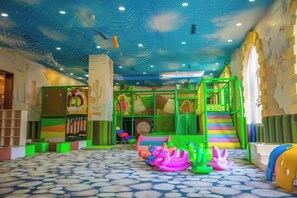 Een kinderspeelplaats met een glijbaan, klimconstructies en vrolijk speelgoed.