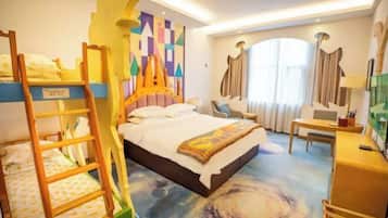 A hotel room with bunk beds, a desk, a chair, and a large window with curtains.