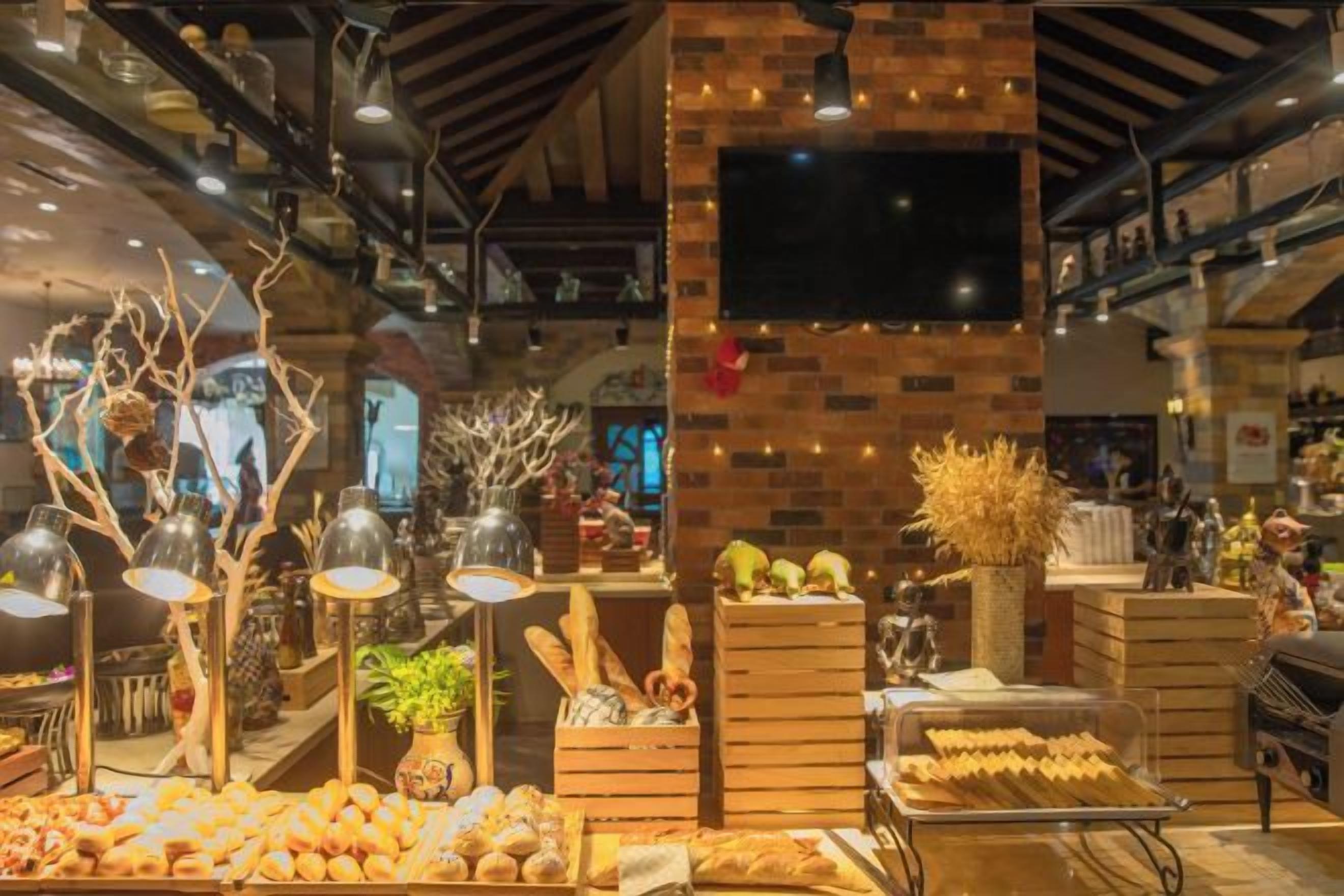 Vitrine de padaria com diversos produtos de panificação e elementos decorativos.
