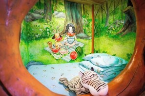 Ein Bett mit einem Zebratier, einem Hund und einem Kind mit einer Wassermelone.