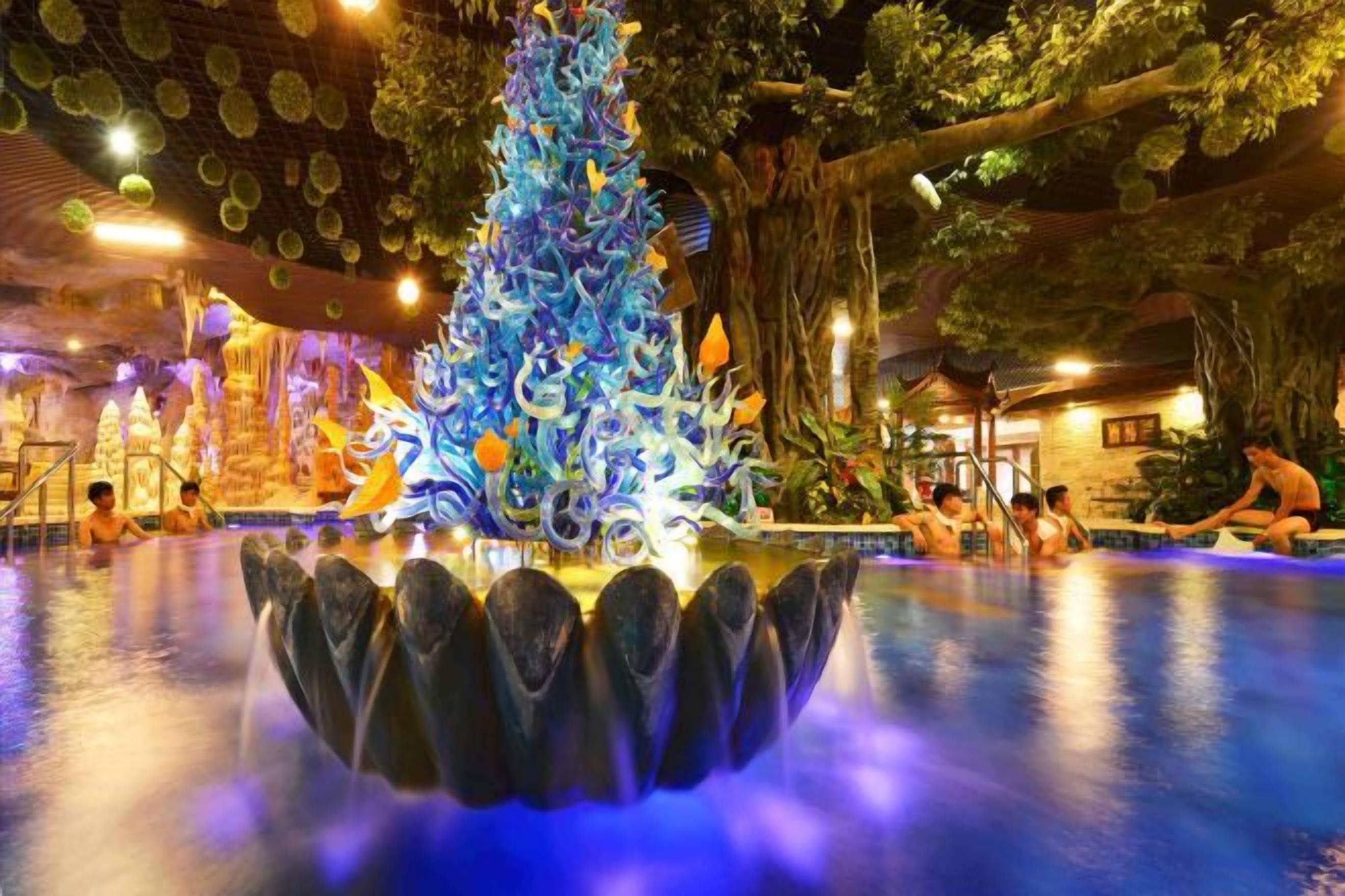 An indoor pool area with a decorative Christmas tree and a fountain.