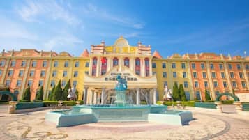 A hotel with a central fountain, multiple buildings, and a clear sky.