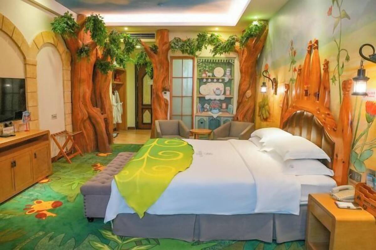 Une chambre avec un lit, un bureau, une chaise et un téléviseur.