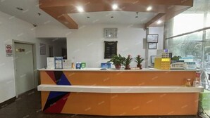 A reception desk with a clock, framed certificates, and a menu board. - Beijing Yixin Express Hotel (Miyun Great Wall Huandao Branch) (Beijing)