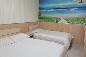A bedroom with two beds, a wooden headboard, a nightstand, and a mural of a beach scene.