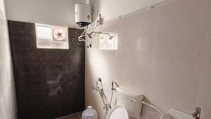 Une salle de bain équipée de toilettes, d’un bidet et d’un lavabo.