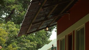 Une rangée de bâtiments rouges, dotés d’auvents verts et de colonnes blanches, qui semblent faire partie d’un hôtel ou d’un complexe touristique.