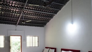 Une chambre avec quatre lits, chacun équipé de serviettes blanches et marron, et un ventilateur de plafond.