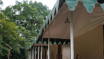 A series of tents with a covered patio area, outdoor seating, and a view of the surrounding greenery.