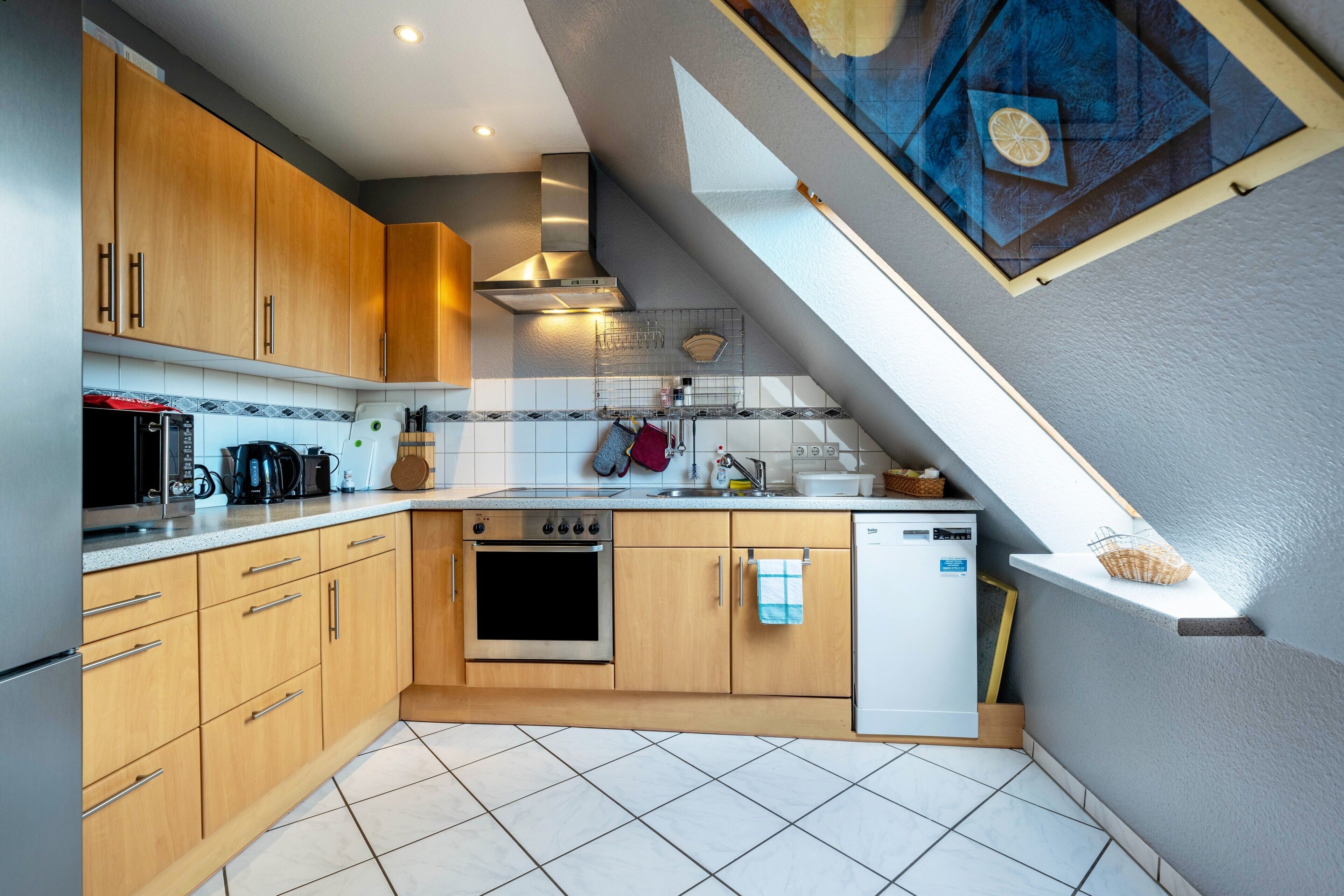 A kitchen with wooden cabinets, a built-in oven, a dishwasher, and a window above the sink.