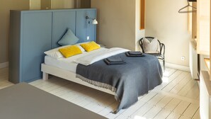 A bedroom with a bed, a hanging light fixture, a chair, and a wardrobe. - Bright Boutique Apartment for a Relaxing Getaway (Großostheim)