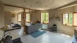 A modern kitchen with a central island, wooden beams, and large windows. - Bright Boutique Apartment for a Relaxing Getaway (Großostheim)
