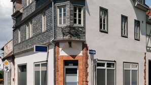 A multi-story building with a prominent tower, large windows, and a red-tiled roof. - Bright Boutique Apartment for a Relaxing Getaway (Großostheim)