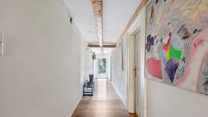 A hallway with wooden flooring, white walls, and a colorful mural on the right wall. - Holiday Apartment Auf Dem Wald 6 Pers. with Mountain View, Private Terrace, and Wi-Fi (Görwihl)