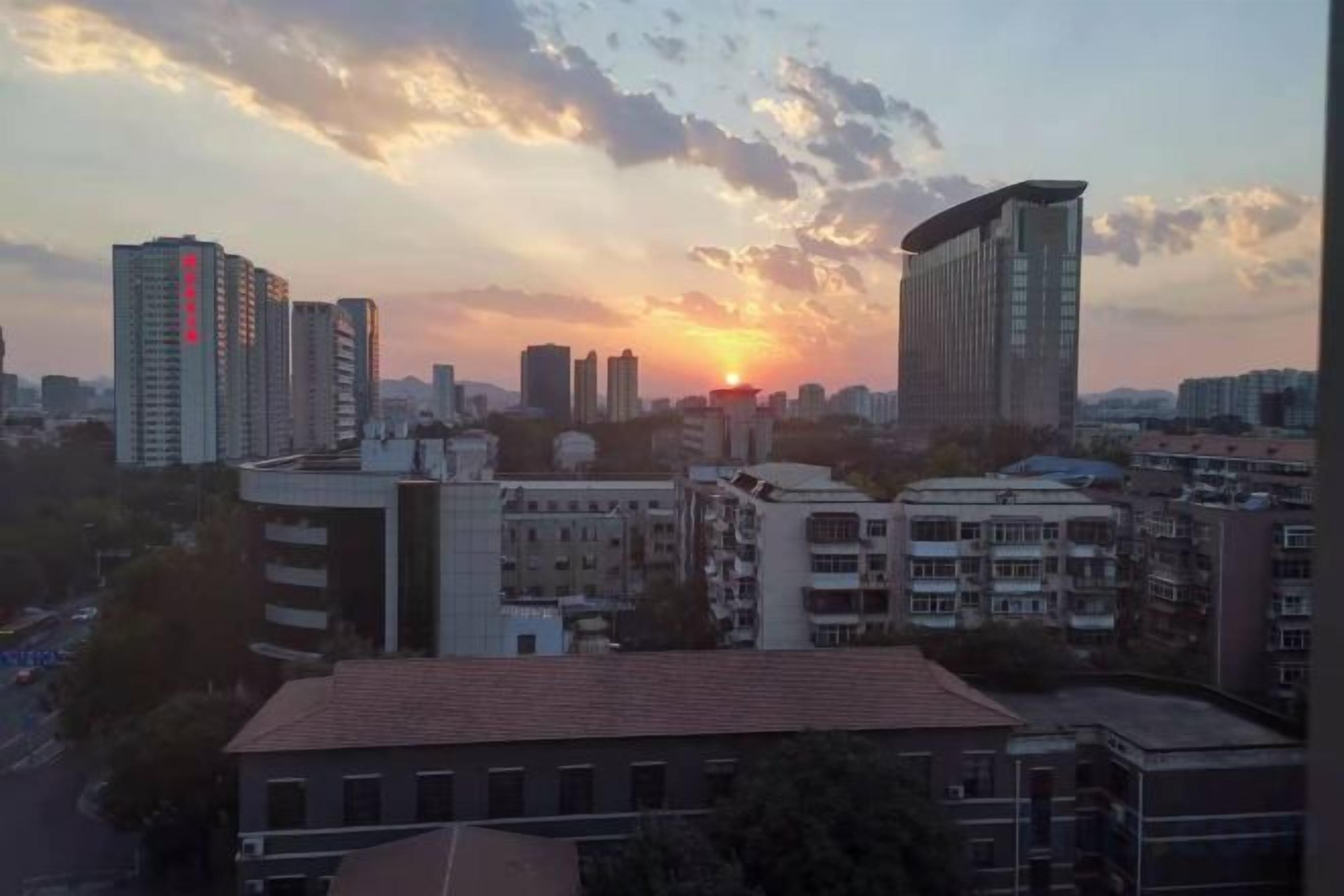 A cityscape with high-rise buildings and a sunset.