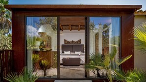 A modern bedroom with a large bed, a bedside table, and a window. - Villa Ashram 6 Emma Villas (Castelvetrano)