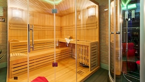 A sauna with wooden benches and glass walls, a bench with a towel, and a glass shower area. - Villa Tiberio 6 2 Emma Villas (Genzano di Roma)