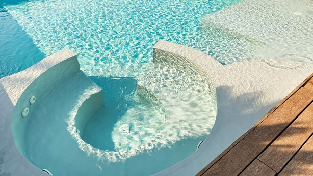 A clear swimming pool with a wooden deck and a stone edge. - Villa Tiberio 6 2 Emma Villas (Genzano di Roma)