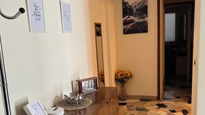 Een receptie met een houten toonbank, ingelijste foto’s, een spiegel en een vaas zonnebloemen.