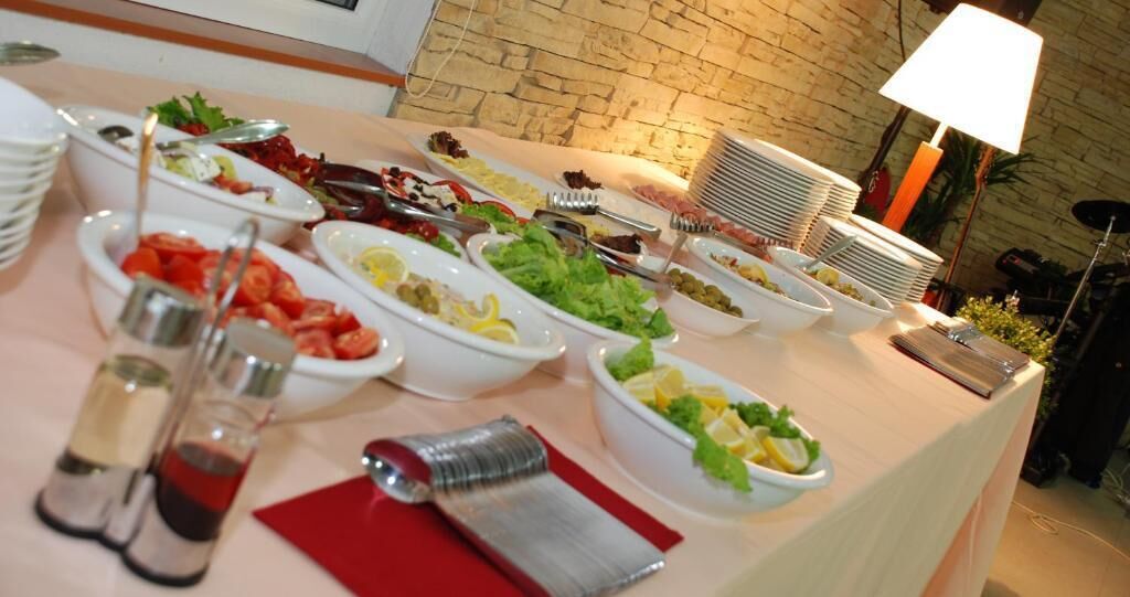 Uma mesa de buffet com diversos alimentos e acompanhamentos.