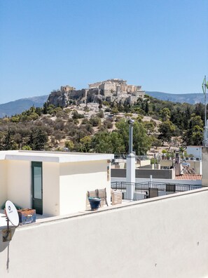 A rooftop terrace with a view of ancient ruins on a hill. - The Observatory 2BR With Acropolis View (Athens)