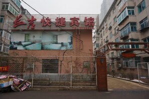 A hotel entrance with a large sign, a gated entrance, and a building facade. - Changji Express Hotel (Liaoyang)