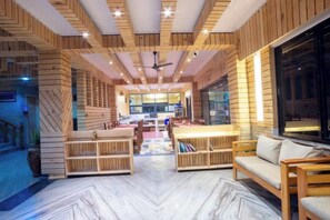 A spacious interior with wooden paneling, a central seating area, and a view through a large window. - Trekkers Inn Boutique Hotel Pokhara (Pokhara)