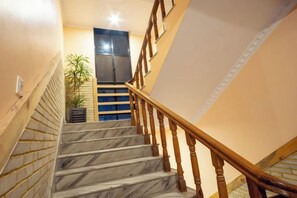 A marble staircase with wooden handrails leading to a landing. - Trekkers Inn Boutique Hotel Pokhara (Pokhara)