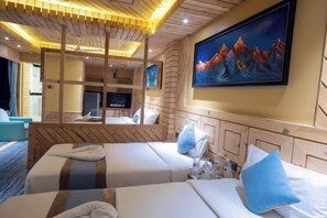 Habitación de hotel con dos camas, un televisor, un cuadro y un diseño de techo de madera.