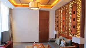 A modern living room with a sofa, coffee table, and TV stand. - Fuquan Xingong Hot Spring Resort (Zunhua)