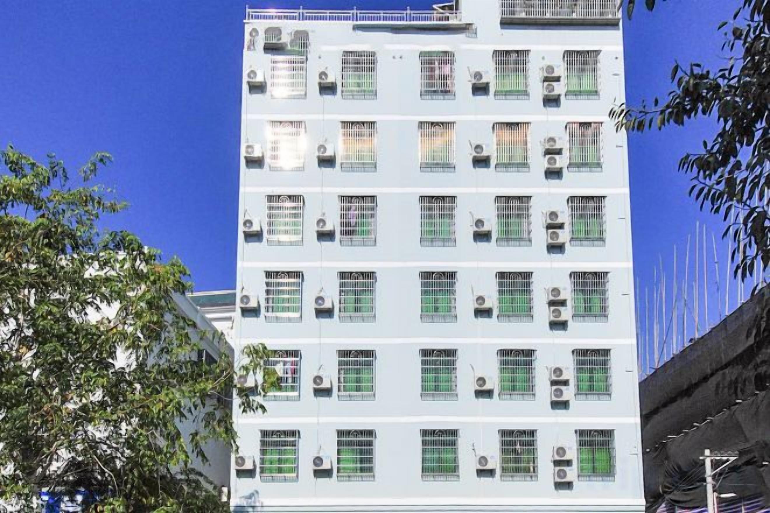 A multi-story building with numerous windows and air conditioning units.