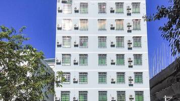 A multi-story building with numerous windows and air conditioning units.