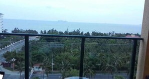 Un balcón con vista al mar y palmeras.